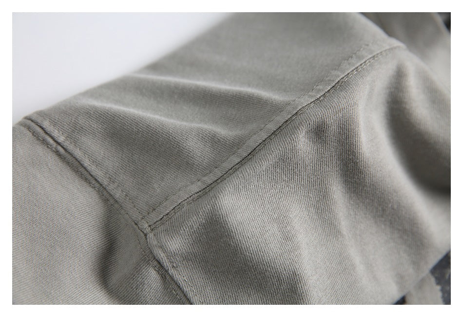 Close-up of the gray T-shirt shoulder seam and stitching.