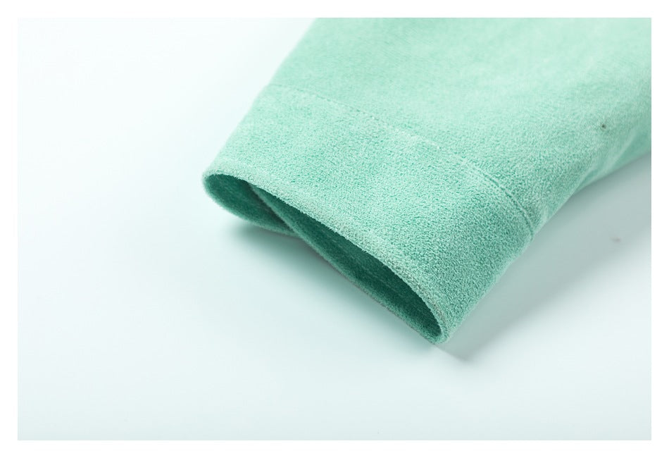 Close-up of the mint-green garment's folded, stitched edge against a white background.