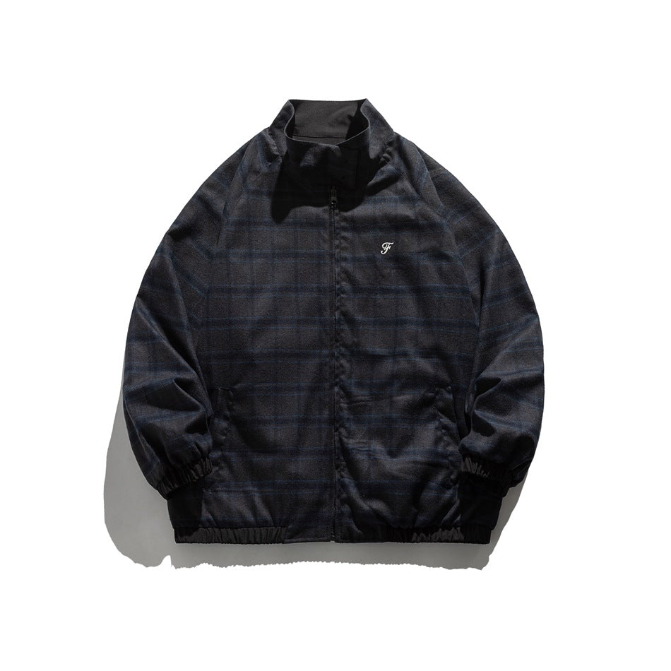 Front view of a dark blue plaid zip jacket with a stand collar, elastic cuffs and hem, and a small chest emblem.