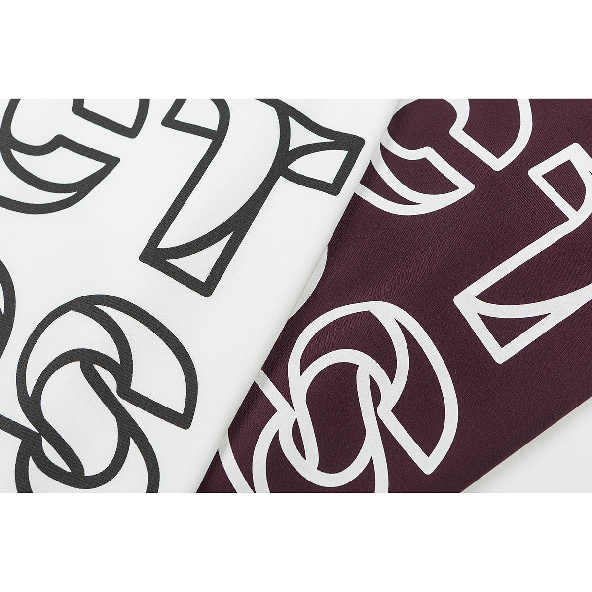 Close-up of large outlined lettering printed on white and burgundy T-shirt fronts.