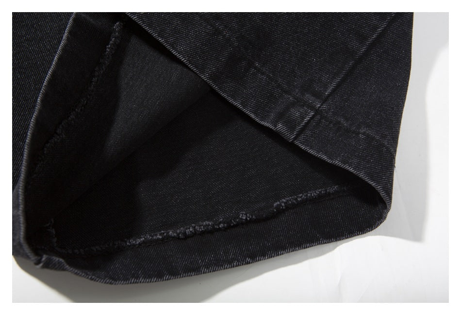 Close-up of a turned-up jeans hem, showing the dark inner fabric and stitched edge.