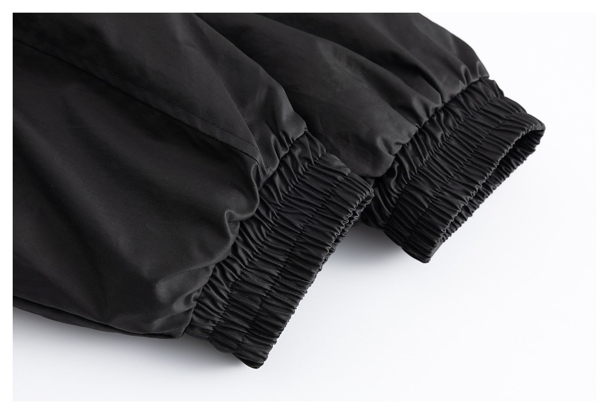 Close-up of two gathered elastic openings on a black garment against a white background.