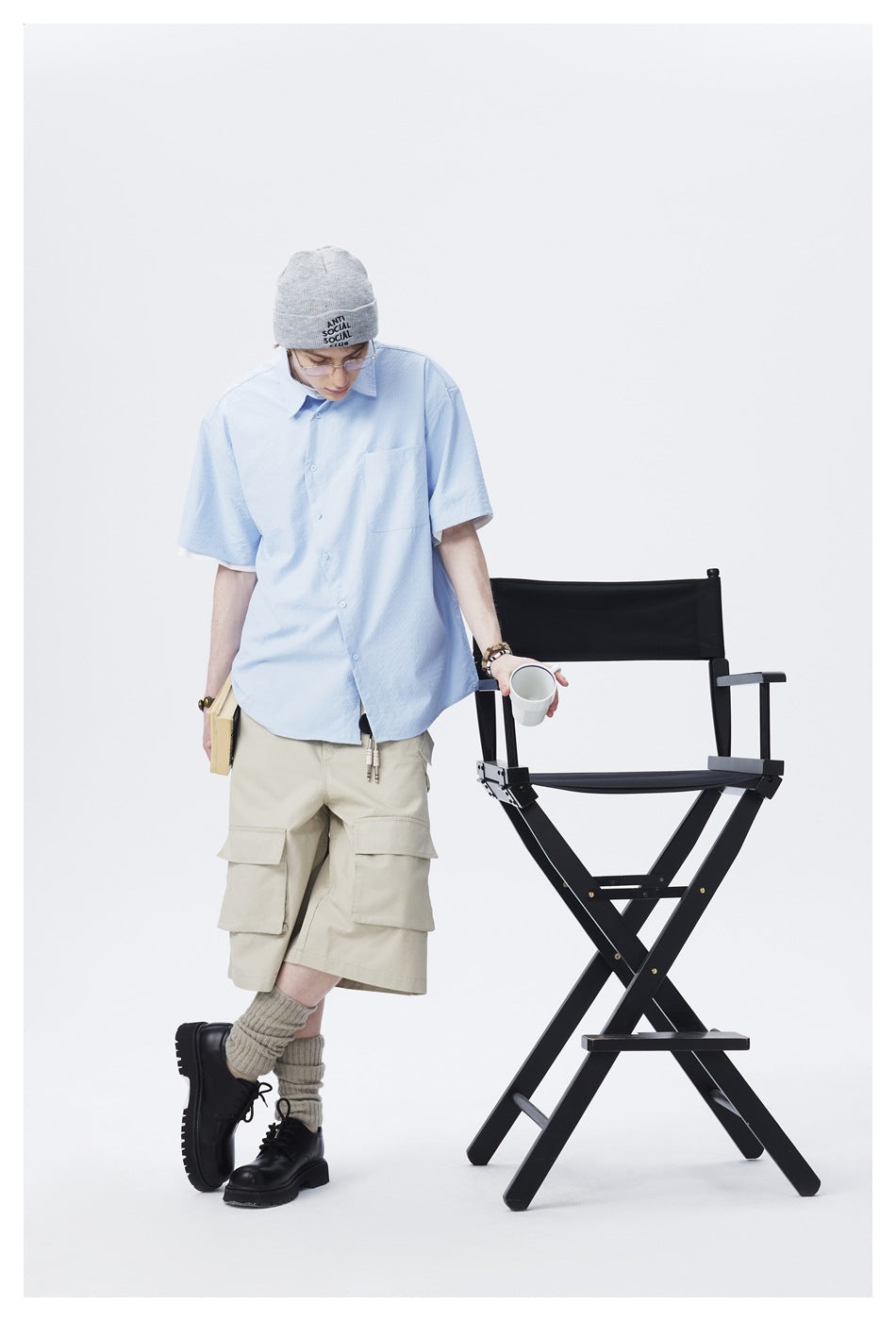 Full-length view of a model wearing a light blue short-sleeve button-up shirt with a chest pocket.