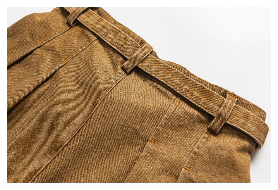 Close-up of brown pants showing the waistband, belt loops, and stitched seams.