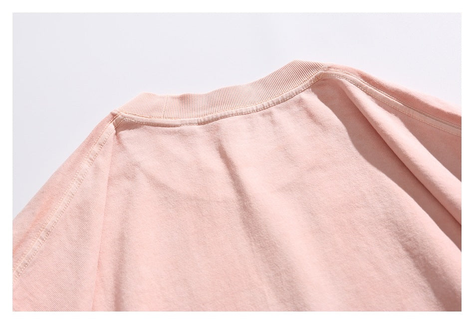 Close-up of the back neckline and shoulder seams on a peach T-shirt.
