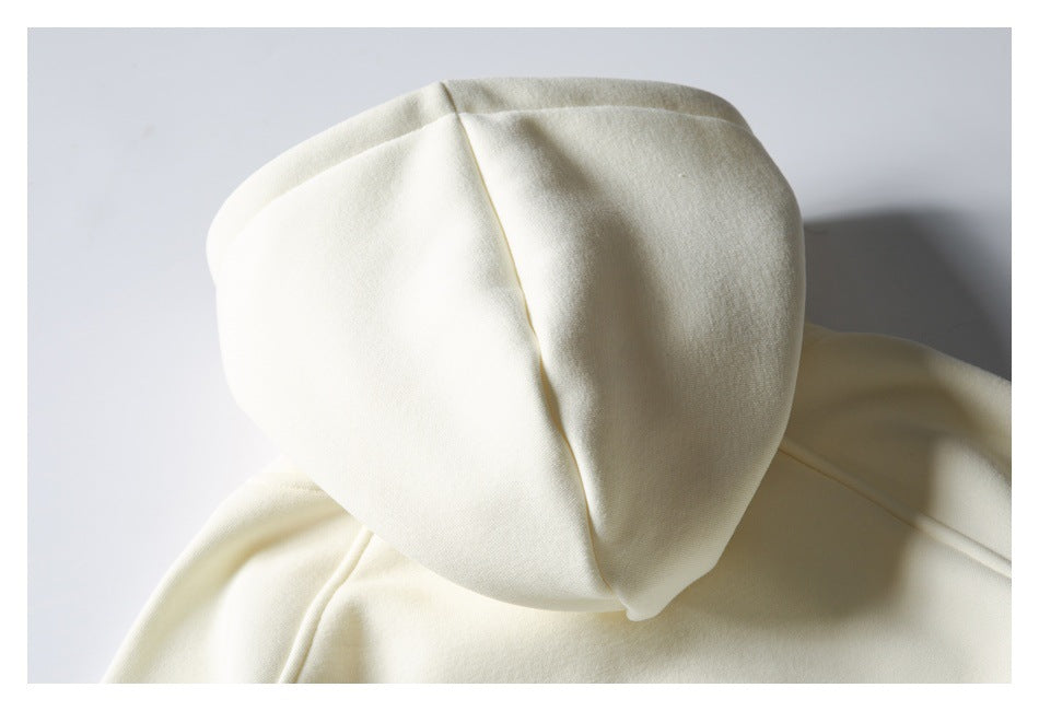 Close-up of the cream sweatshirt hood laid flat, showing its panel seams.