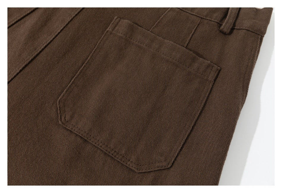 Close-up of a large patch pocket and belt loop on brown trousers.