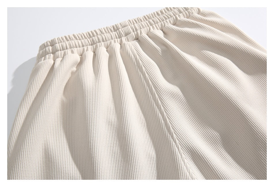 Close-up of cream ribbed shorts showing the gathered elastic waistband and upper legs.