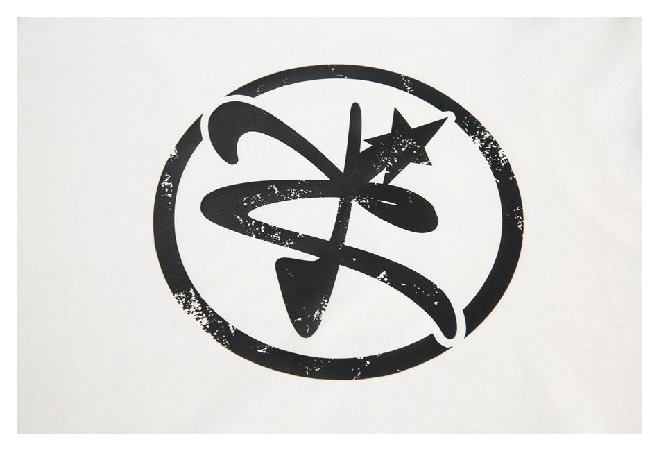 Close-up of a distressed black circular abstract graphic printed on white fabric.