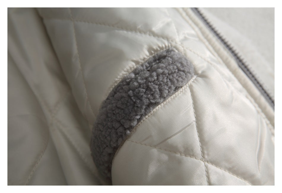 Close-up of a gray fuzzy trim strip on the cream quilted jacket lining.