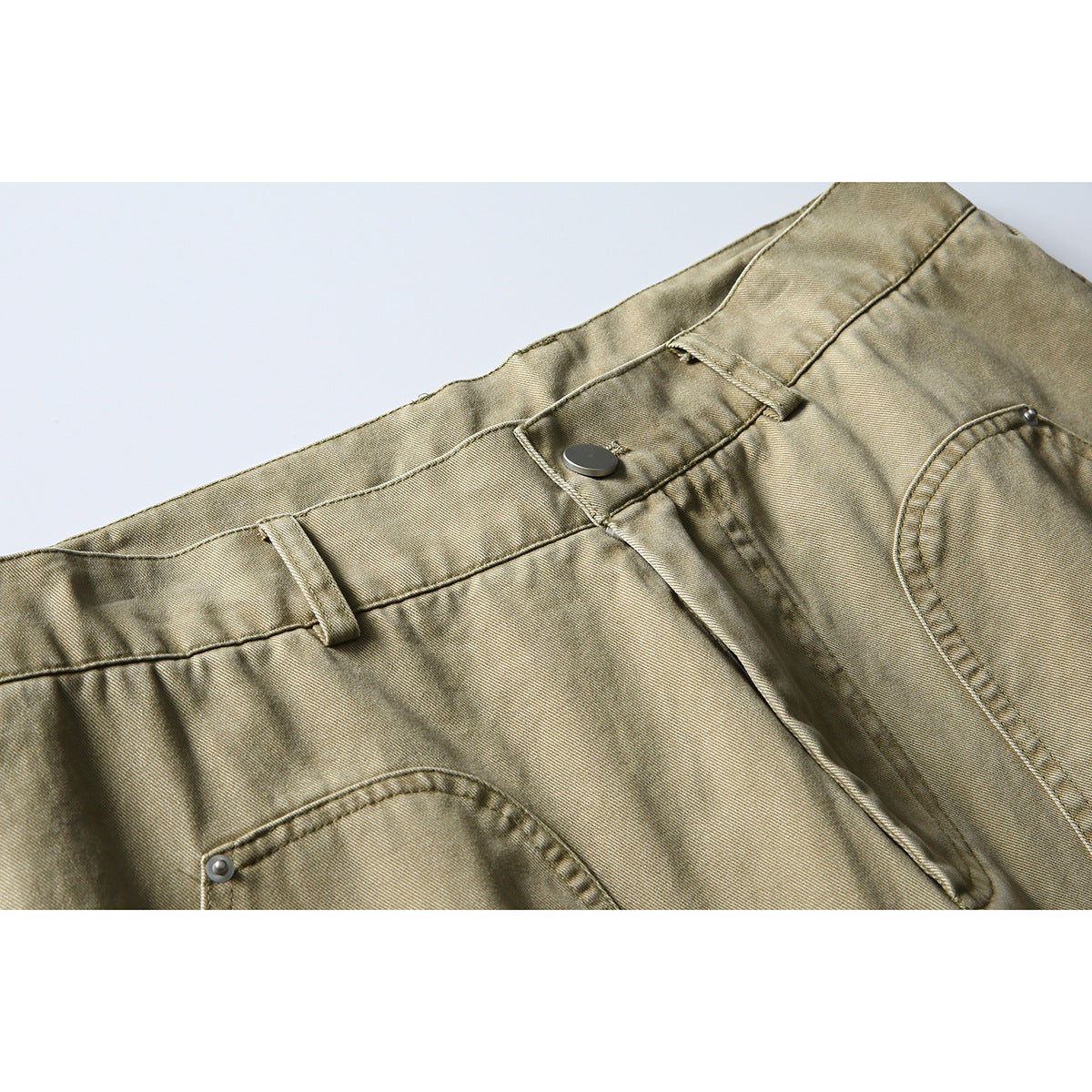 Close-up of khaki pants showing the waistband, button, belt loops, fly, and front pocket.