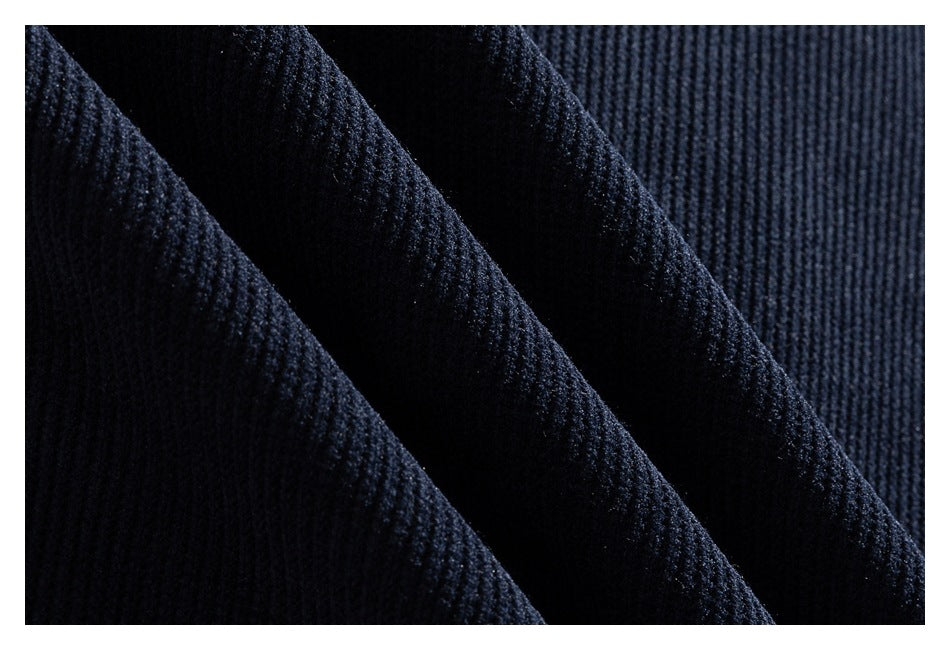 Macro view of dark navy ribbed fabric folded to show its raised texture.