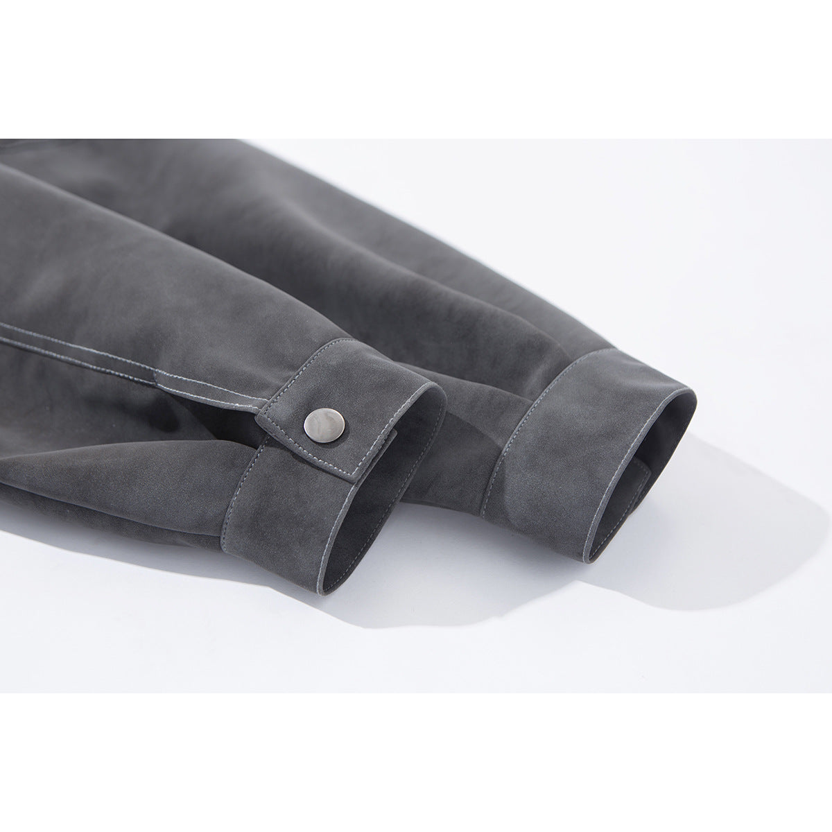 Close-up of charcoal gray jacket sleeves with snap-button cuffs and contrast stitching.