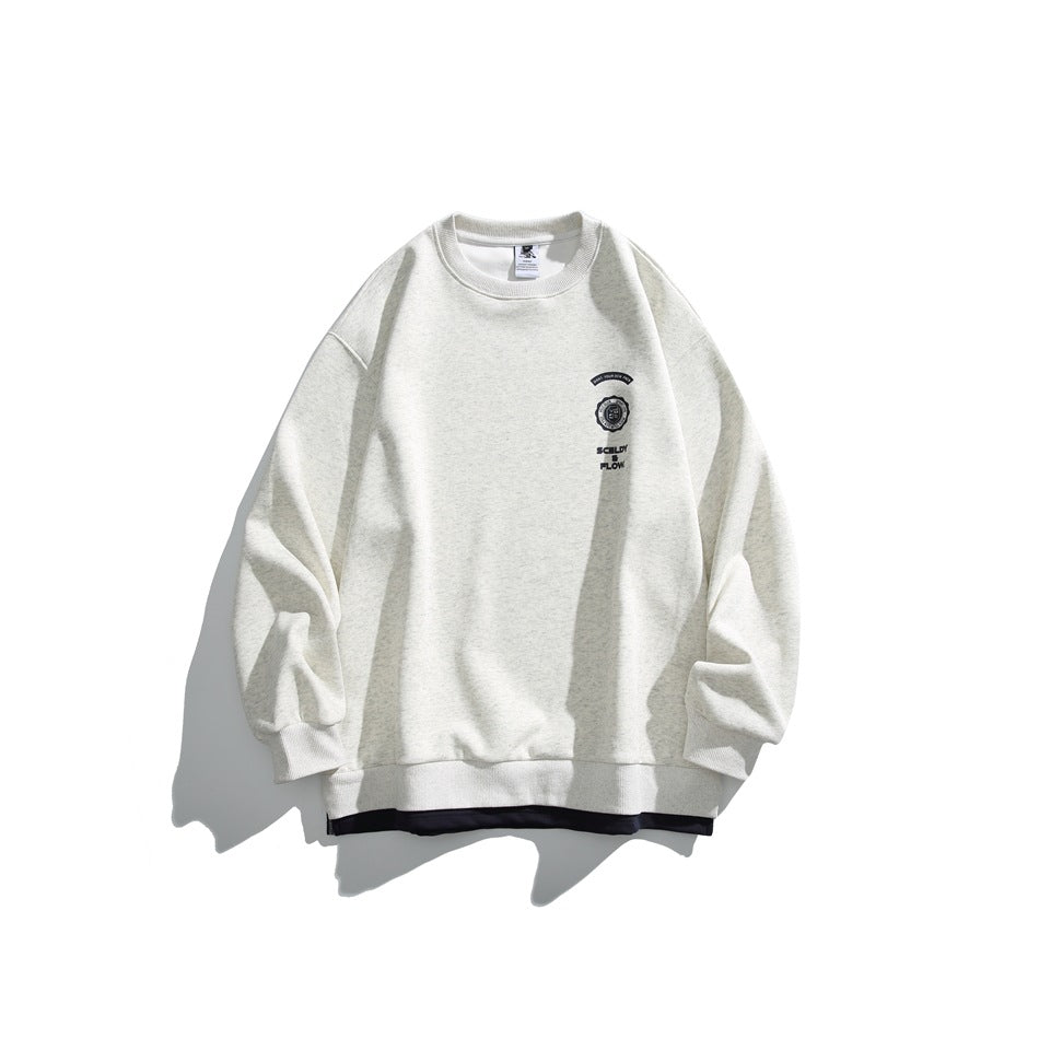 Light heathered gray crewneck sweatshirt flat lay with small chest crest print and dark layered underhem
