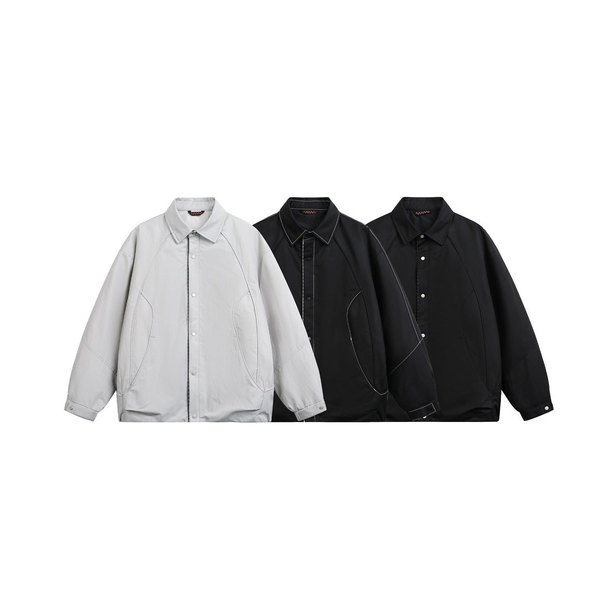 Three collared jackets displayed together in light gray and two black colorways, with snap fronts and curved pockets.