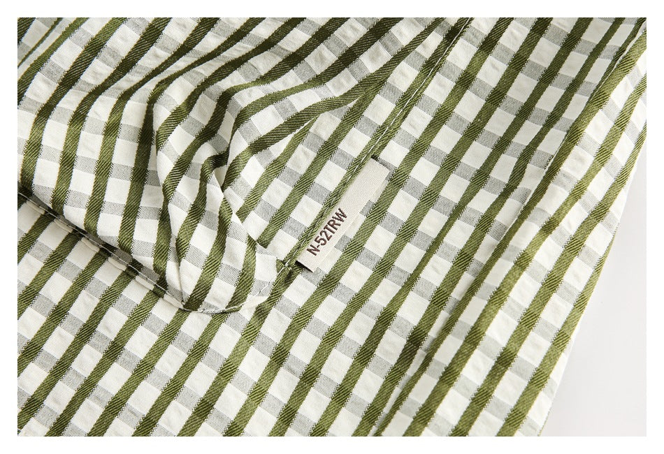 Close-up of olive green and cream checked fabric with raised stripes and a small sewn label.