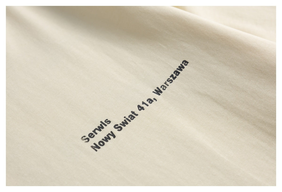 Close-up of a black text print on cream fabric, including a Warsaw address.