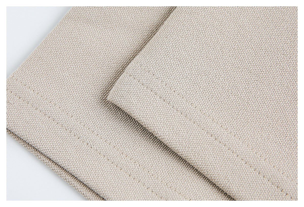 Close-up of beige knit fabric showing a folded edge and stitched seam.
