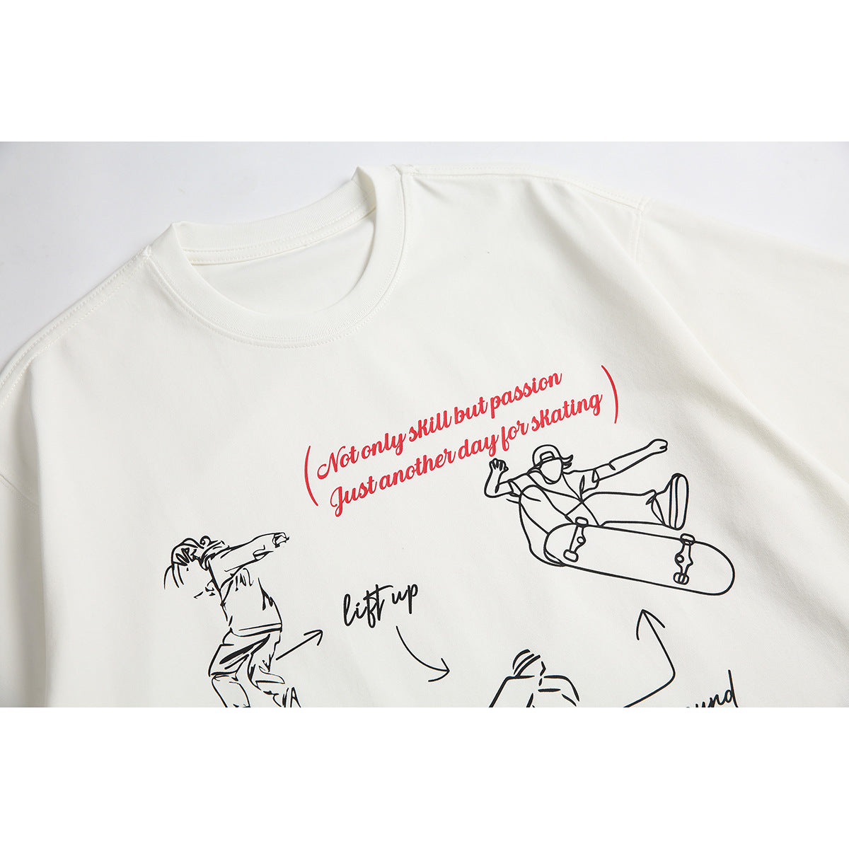 Close-up of an off-white T-shirt front with red script and black skateboarding illustrations.