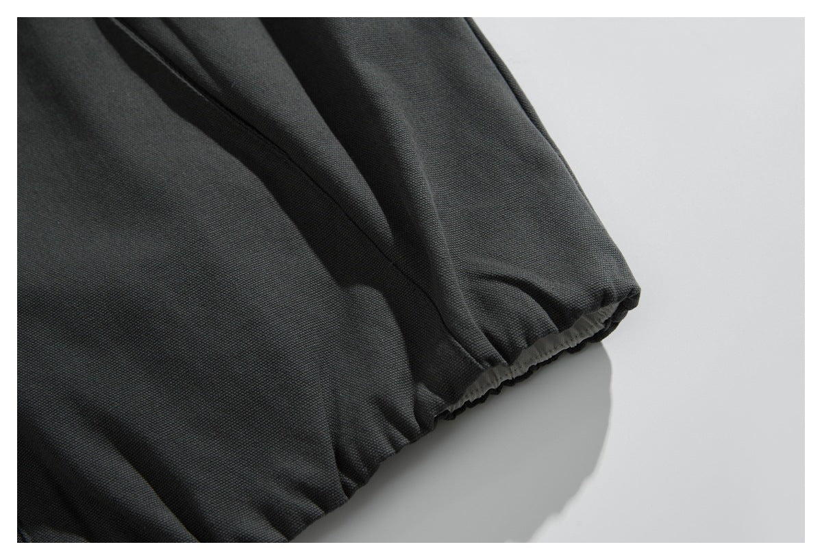Close-up of a charcoal garment sleeve with a gathered elastic cuff.