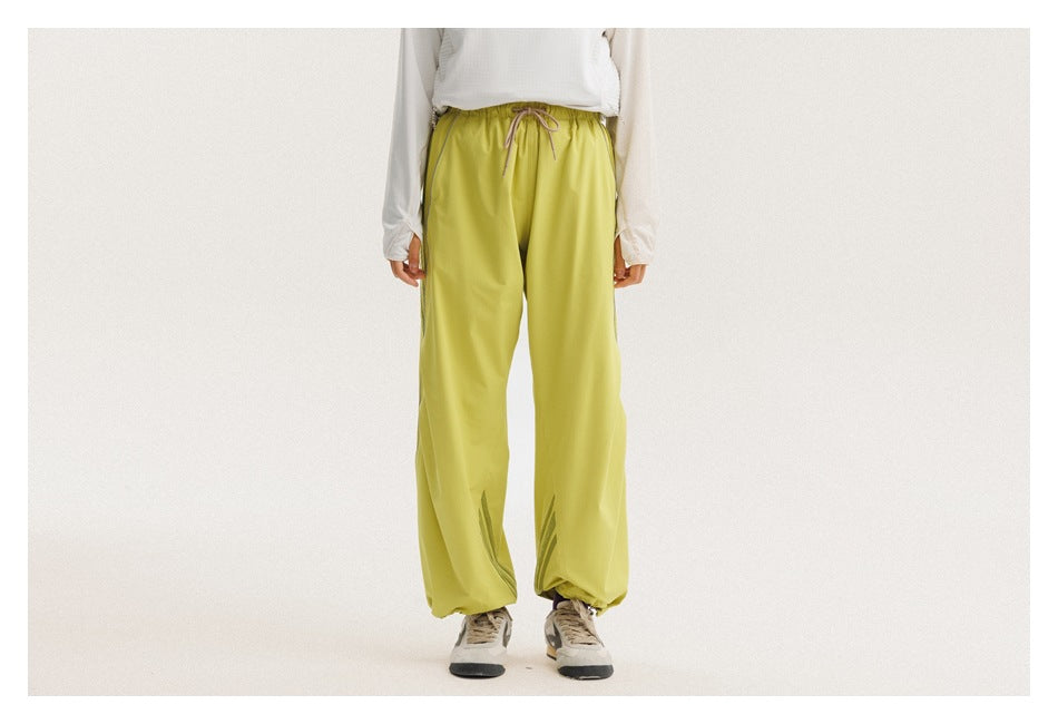 Front view of a model wearing bright yellow-green jogger pants with a drawstring waist and gathered cuffs.