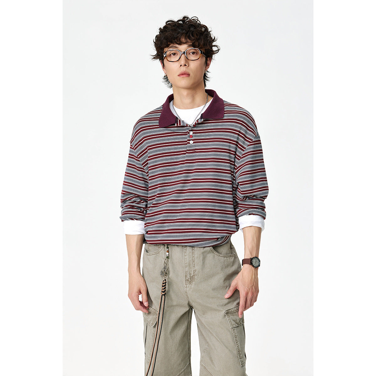 Front view of a model in a burgundy, gray and white striped long-sleeve polo with a dark collar and khaki cargo pants.