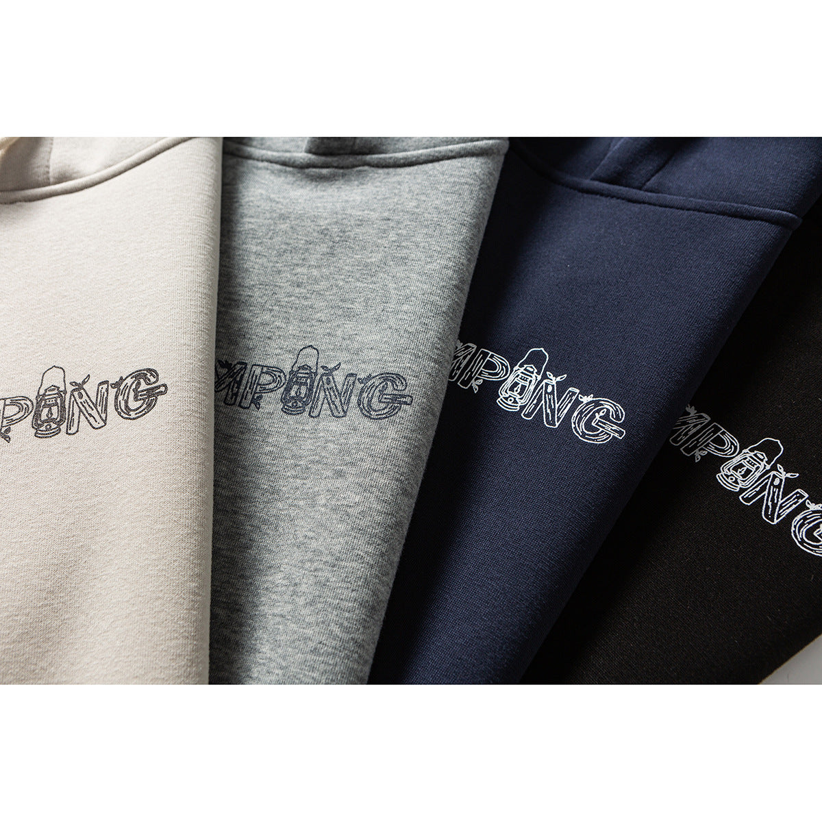 Close-up of four hoodies in beige, heather gray, navy, and black, each with outlined chest lettering.