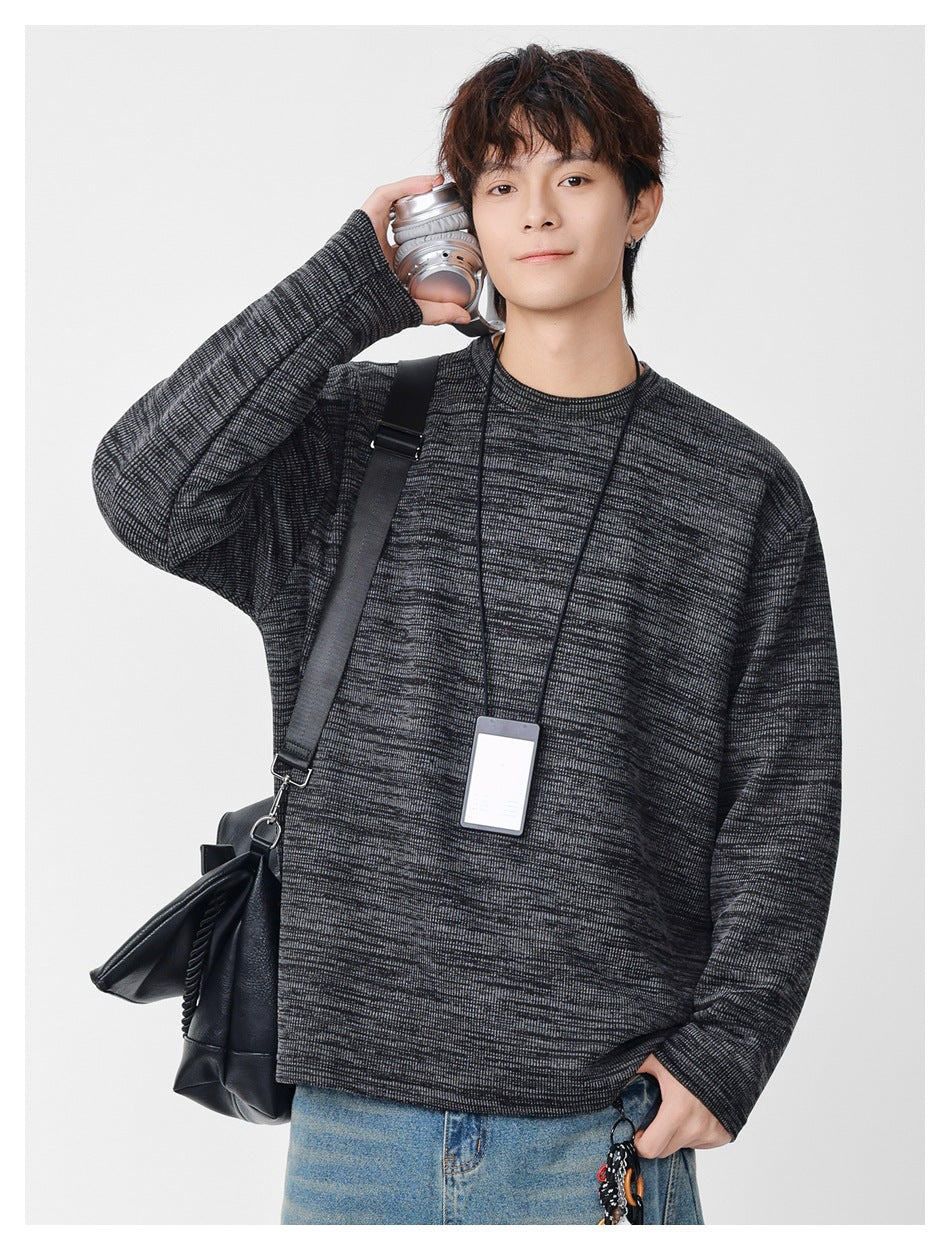 Model wearing a charcoal marled crewneck sweatshirt with long sleeves and a relaxed fit.