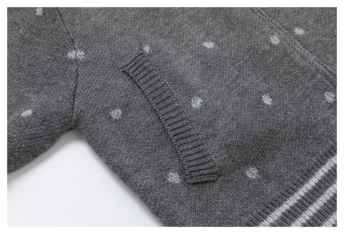 Close-up of gray dotted knit fabric, a stitched pocket opening, and a section of striped hem.