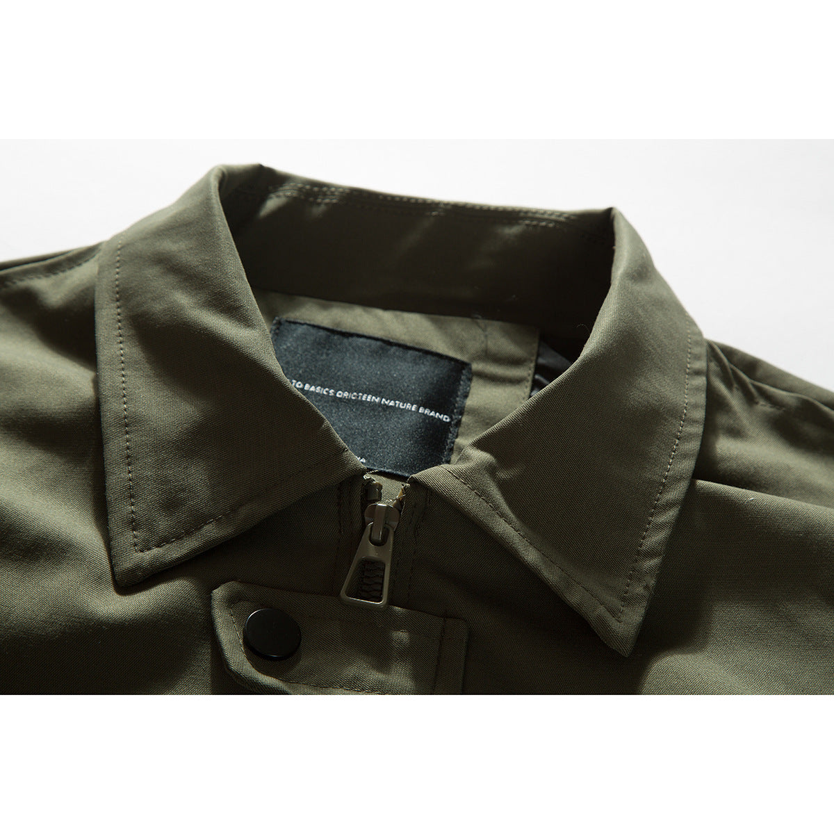 Close-up of an olive-green jacket collar, zipper, snap tab and sewn-in neck label.