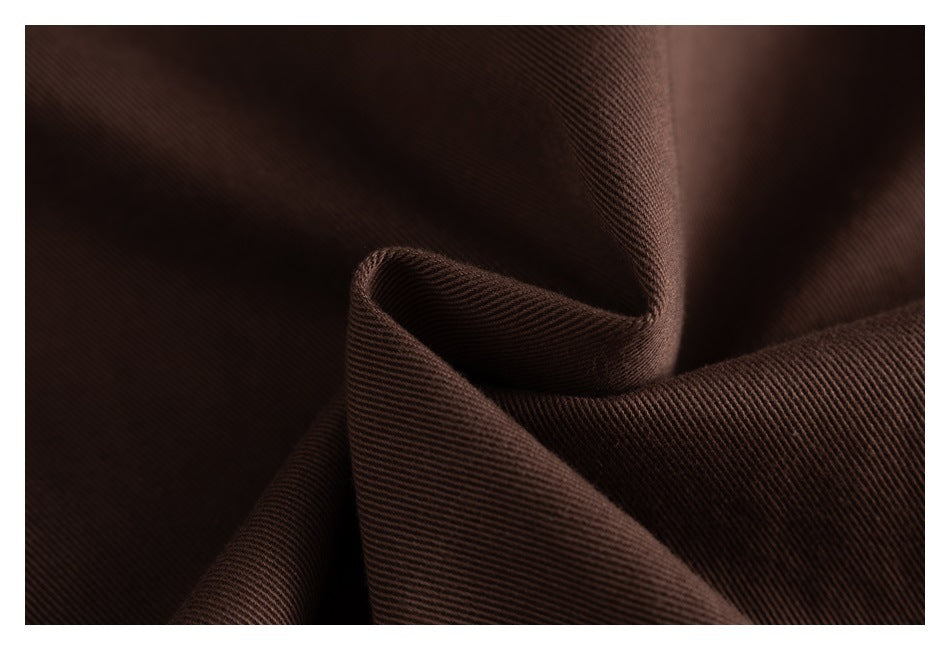 Macro view of dark brown jacket fabric folded to show its diagonal weave.