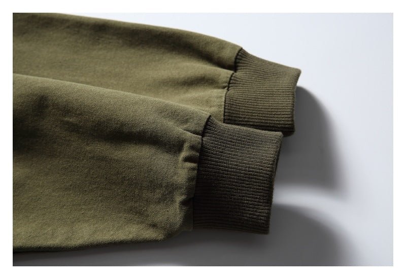 Two olive sleeves lie side by side, showing their dark ribbed cuffs.