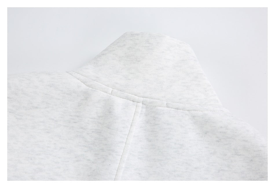 Close-up of the hood and center seam on a light gray marled garment.