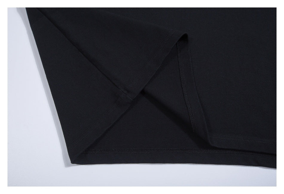 Close-up of the black T-shirt's side seam and finished lower hem.