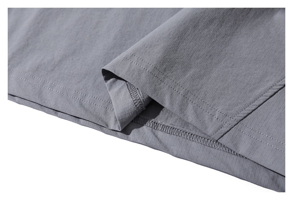 Close-up of a gray sleeve cuff and garment hem, showing stitching and the inside seam finish.