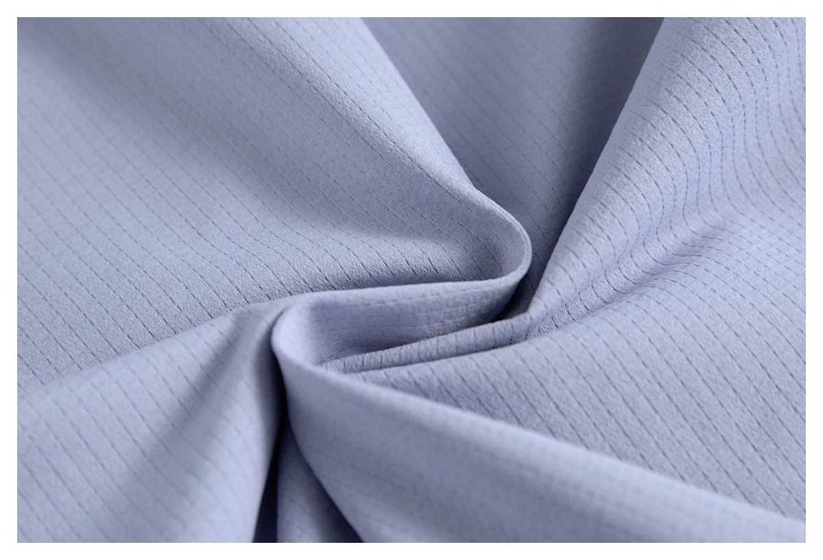 Close-up of softly folded pale lavender fabric with fine linear texture and subtle raised patterning.
