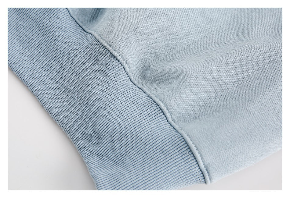 Close-up of the pale blue sweatshirt body meeting a wide ribbed band.