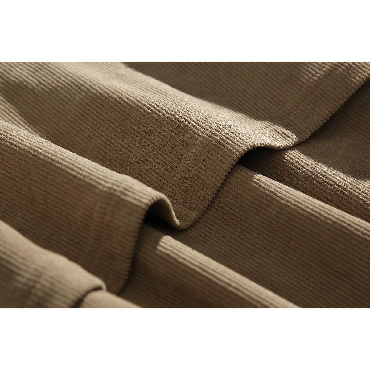 Close-up of tan corduroy jacket fabric and folded seam details.