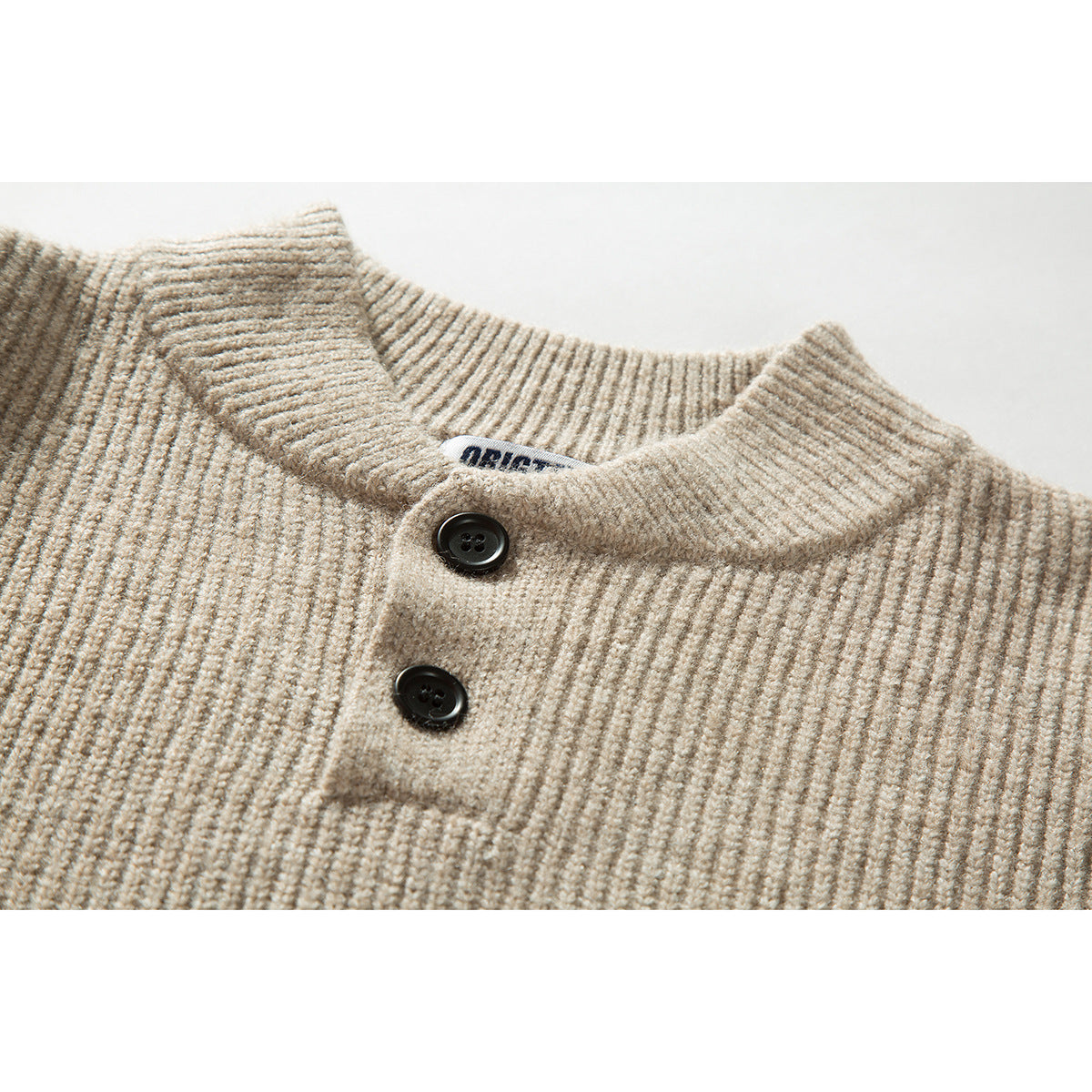 Close-up of a beige rib-knit sweater collar and two-button placket.