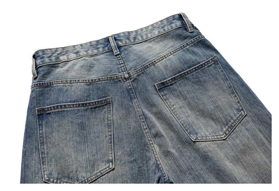 Cropped back view of faded blue jeans showing the waistband, belt loops, yoke, and two pockets.