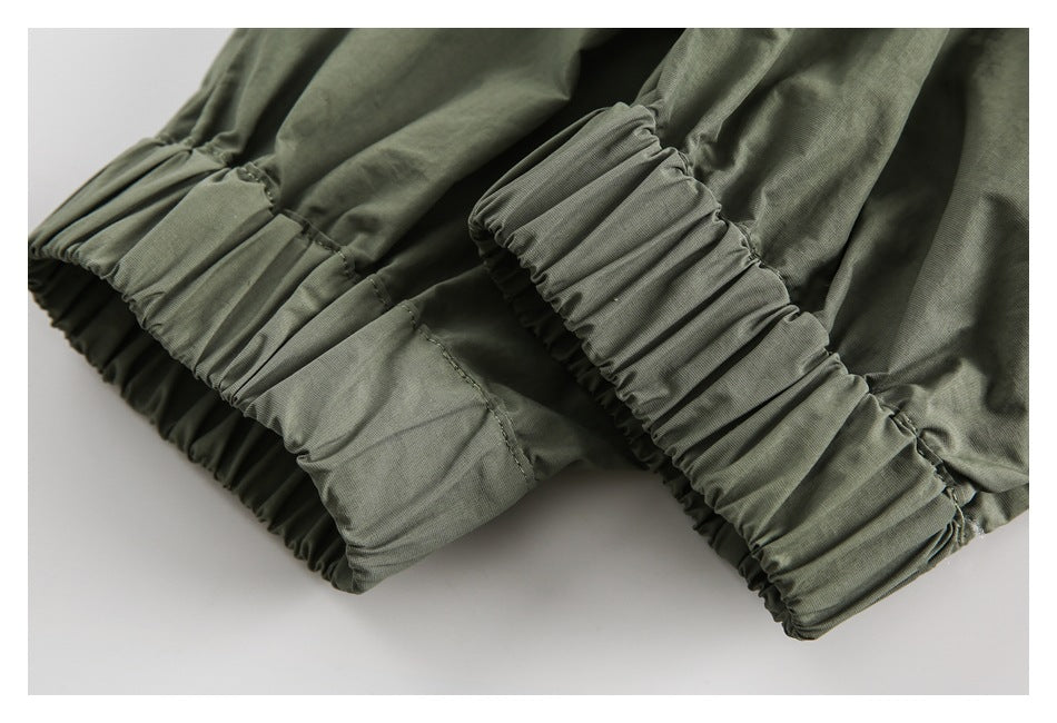 Close-up of gathered elastic cuffs on an olive-gray garment.