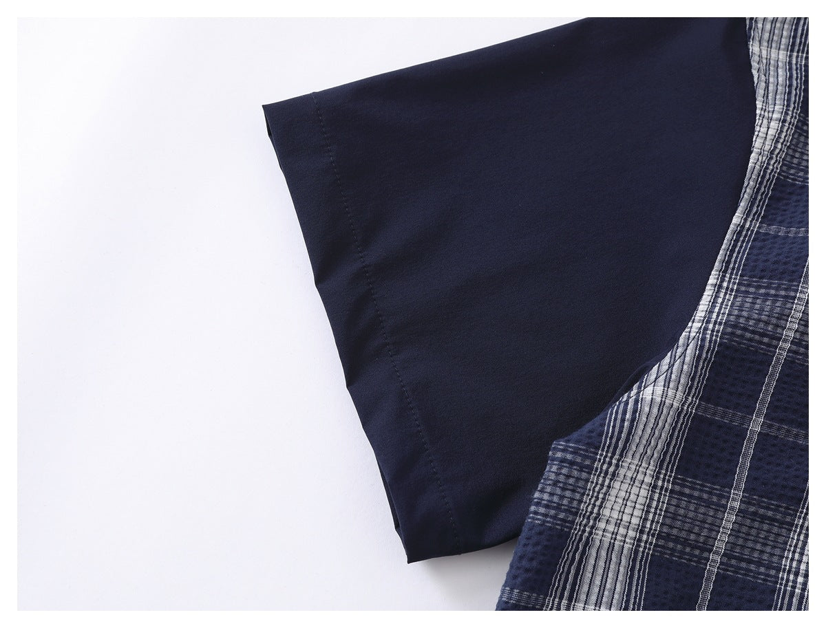 Close-up of a plain navy sleeve beside a navy-and-white plaid garment panel.