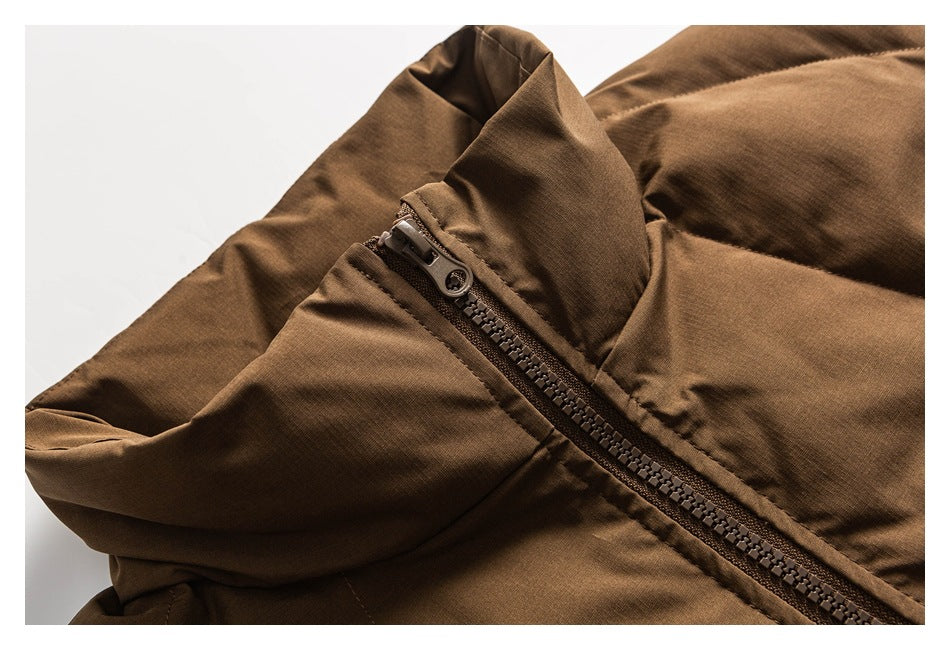 Close-up of a brown jacket's diagonal front zipper and raised collar.