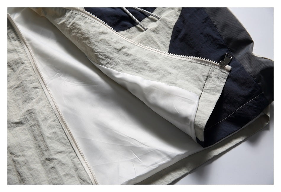 Close-up of the jacket's open front zipper, showing its white lining and navy color-block panels.