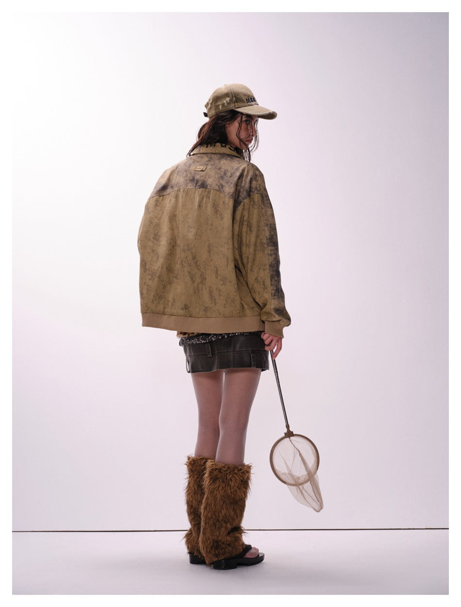 Model wearing the back of an oversized mottled tan-brown jacket with darker sleeves and ribbed cuffs and hem.