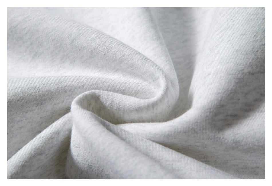 Close-up of folded light gray heathered fabric showing its knit texture.
