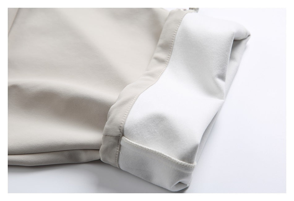 Close-up of a light beige garment edge showing stitching and a soft-looking inner layer.