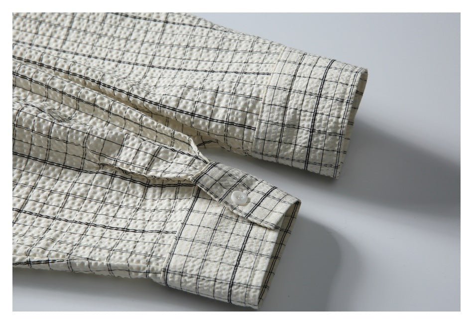 Close-up of the shirt's checked sleeve and buttoned cuff against a plain background.