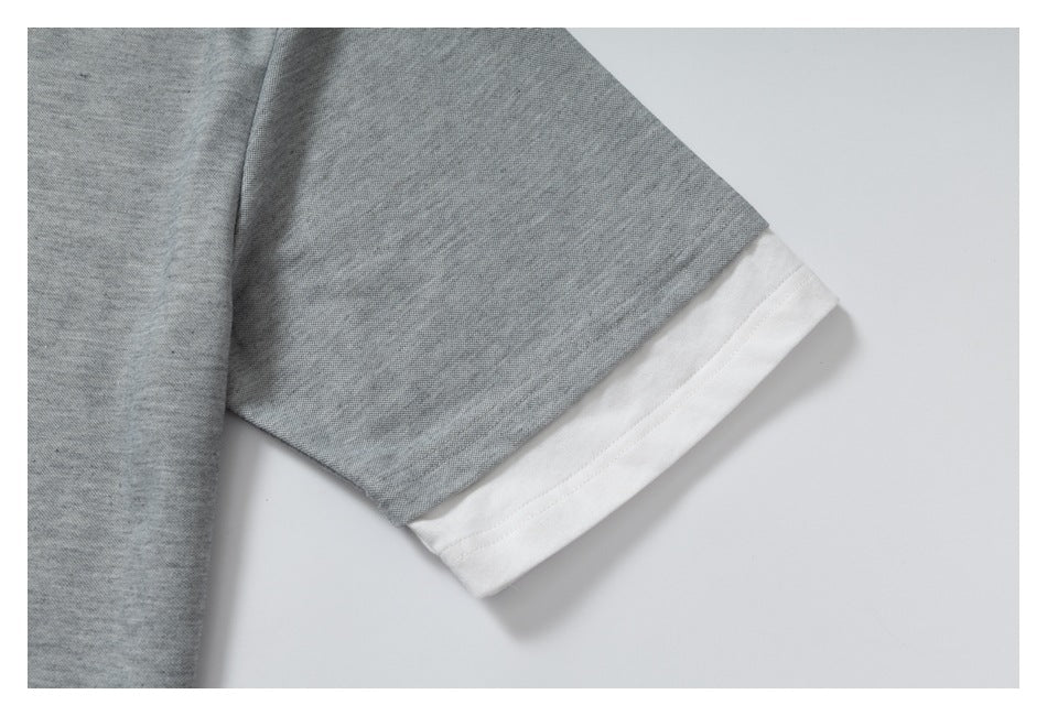 Close-up of a gray short sleeve finished with a wide white cuff band.