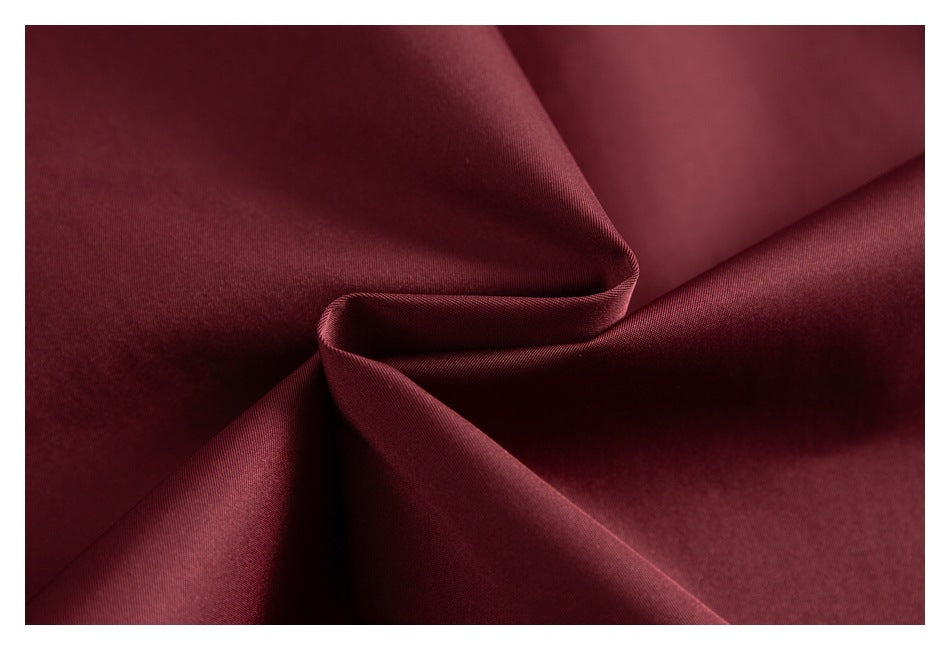Close-up of smooth burgundy jacket fabric gathered into folds.